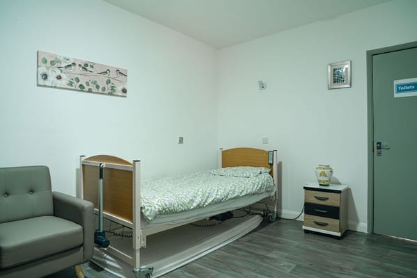 A well-furnished resident room with a hospital bed