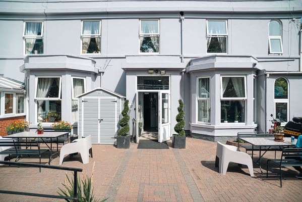 Exterior view of Forest Lodge Care Home with patio area