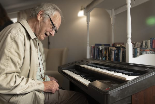 Resident playing the piano in a common area