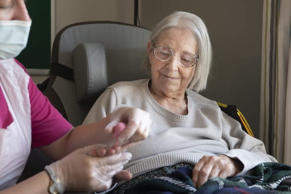 A staff member caring for a smiling resident