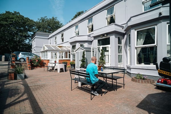 Resident enjoying time in the courtyard of Forest Lodge Care Home