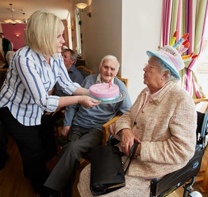 Residents enjoying a birthday celebration with cake