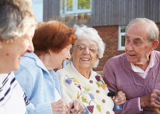 Four residents enjoying a cheerful conversation outdoors