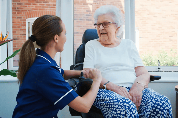 Caregiver interacting with a resident in a sunlit room