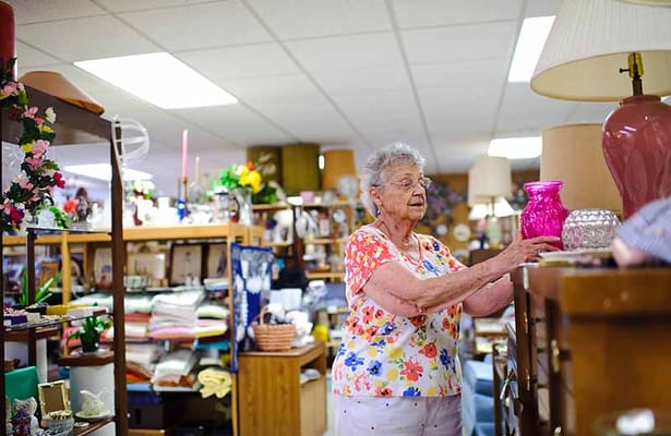 An elderly woman browsing in a vintage thrift shop