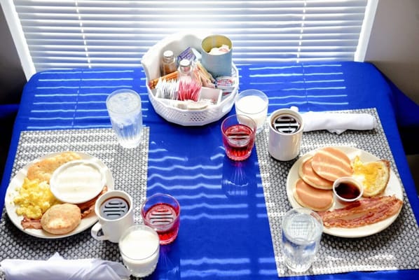Breakfast setup with pancakes, eggs, and drinks
