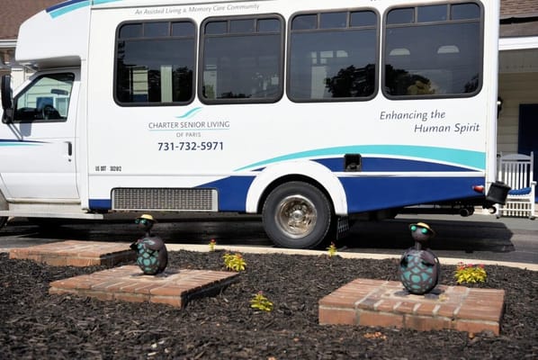 Facility transport van parked with garden decor