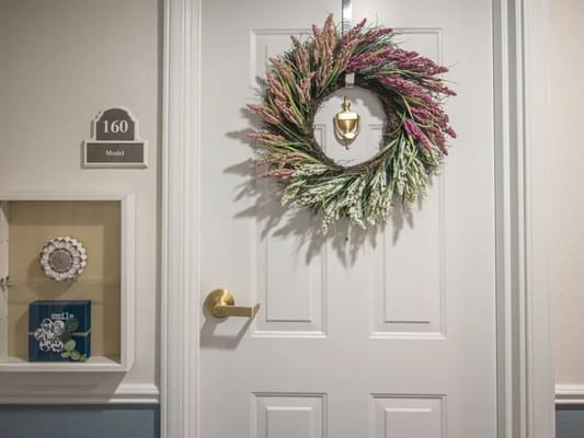 A decorated door with a floral wreath and nameplate