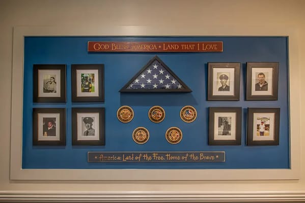Honor wall featuring photographs and military memorabilia