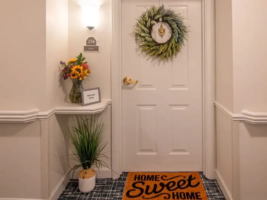 Cozy resident entrance with welcome mat and floral decor