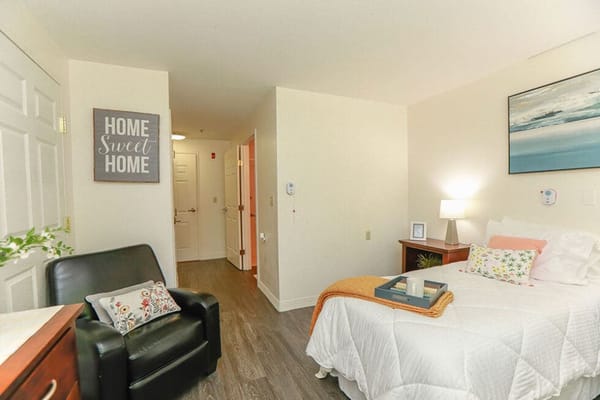 Cozy resident room with a bed and armchair