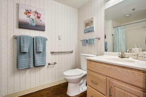 A well-appointed resident bathroom with flowers and towels
