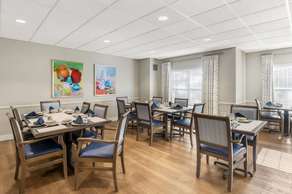 Bright dining room with tables set for residents
