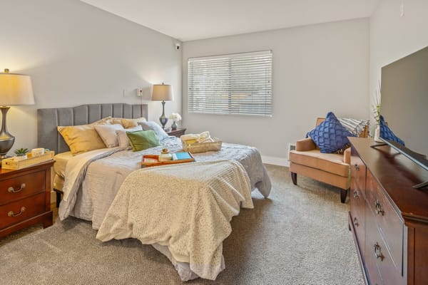 A cozy interior room with a bed and seating area