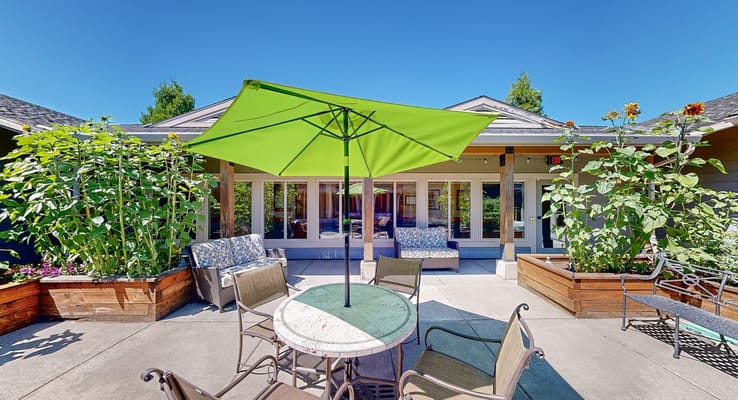 Outdoor patio with green umbrella and seating