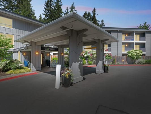 Covered entrance of a senior living facility with landscaping