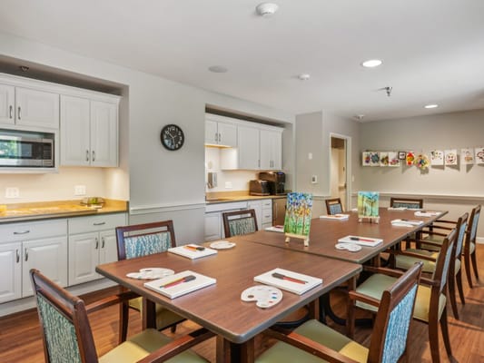 Bright common area with a large dining table and art on the walls