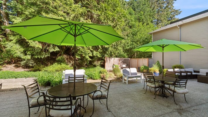 Outdoor seating area with green umbrellas and garden