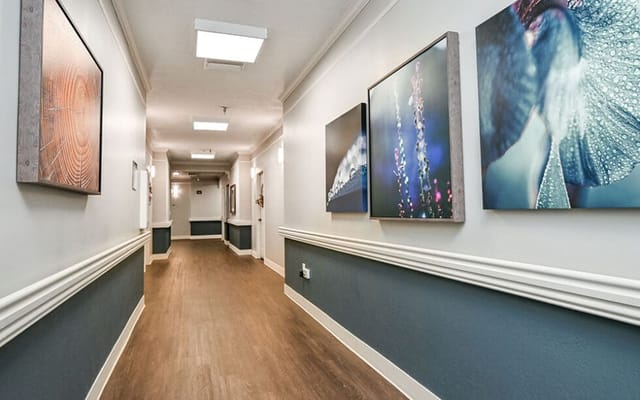 A well-lit corridor with artwork on the walls.