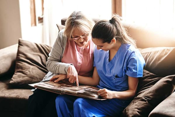 A resident looking at a photo album with a caregiver
