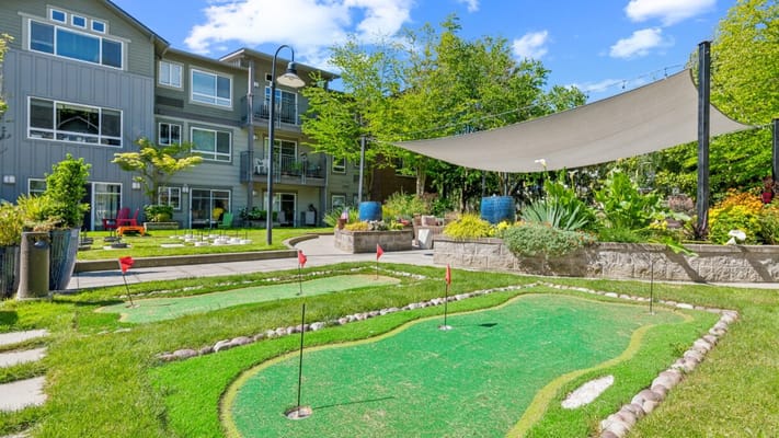 A well-maintained outdoor putting green with garden
