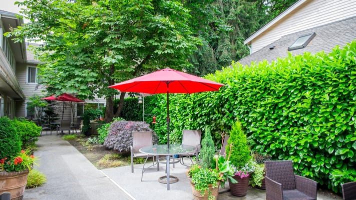 Outdoor patio with red umbrellas and greenery