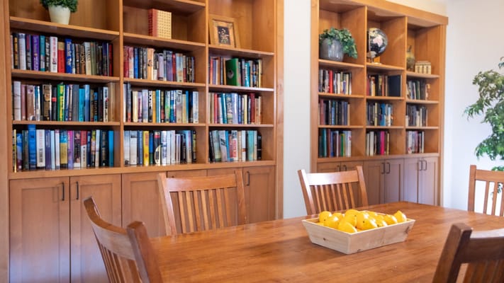 A cozy reading area with bookshelves and a wooden table.