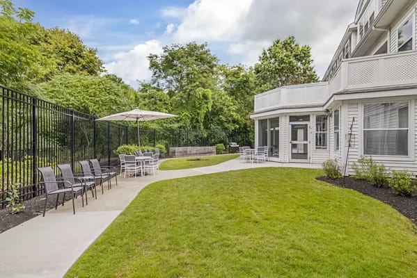 Outdoor seating area with chairs and greenery