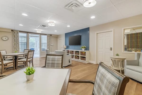 Bright common area with seating and a large TV