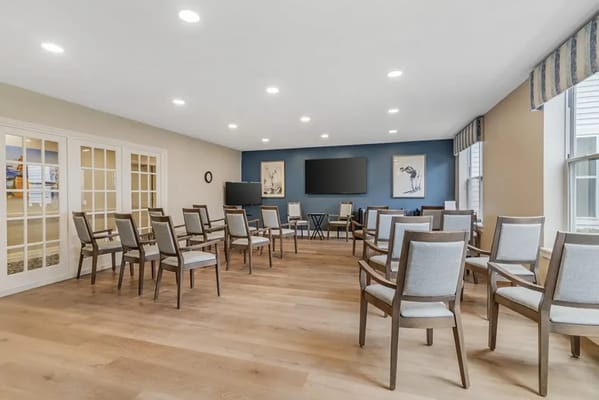 Empty activity room with chairs arranged for residents