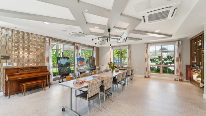 Bright common area with a piano and art displays