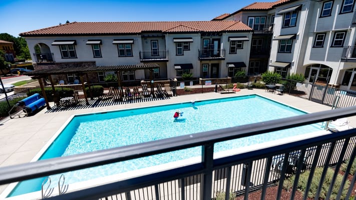 Outdoor pool area with residents enjoying the sun