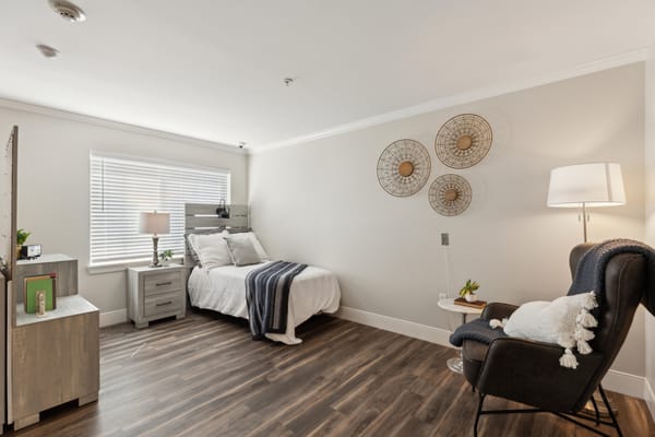 Bright, cozy private room with a bed and armchair