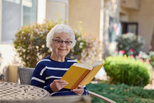 Senior woman reading a book in an outdoor space