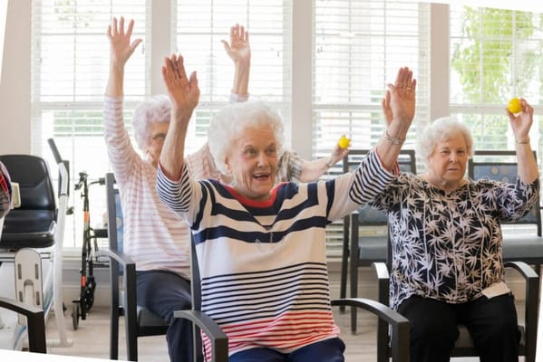 Residents participating in exercise class with raised hands