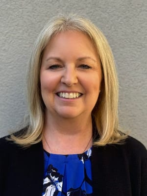 Staff member smiling against a neutral background