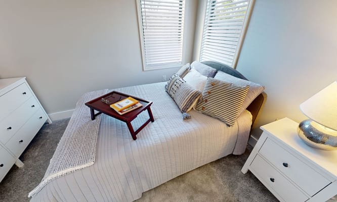 Cozy resident bedroom with a made bed and side table
