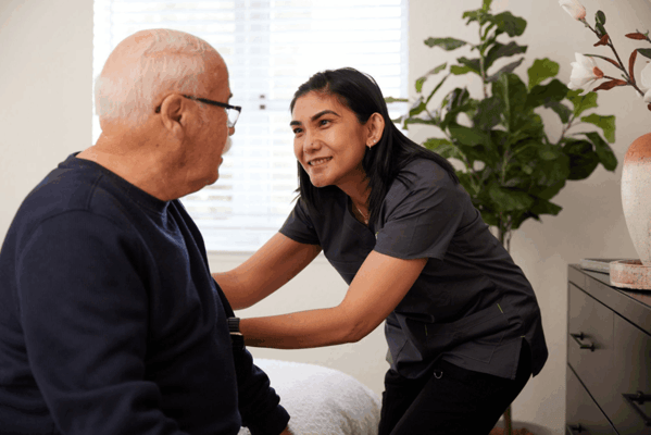 Staff assisting a resident in a cozy room