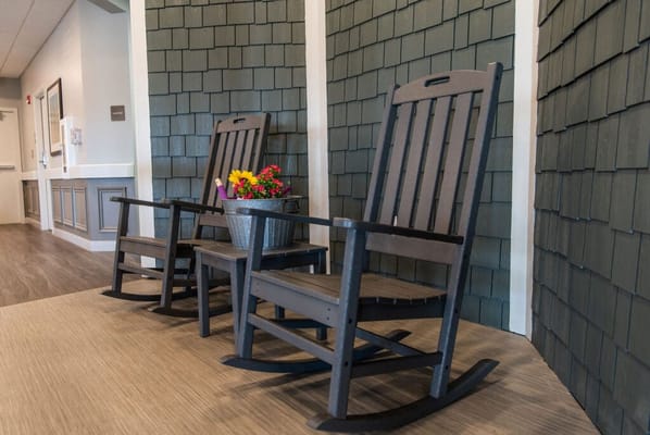 Two rocking chairs with a flower pot in a cozy indoor space
