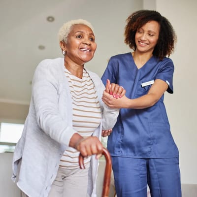 Caregiver assisting a resident in a bright interior space