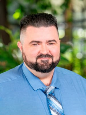 Well-dressed staff member smiling in a lobby