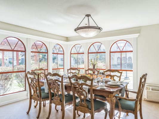 Elegant dining room with large windows and wooden furniture