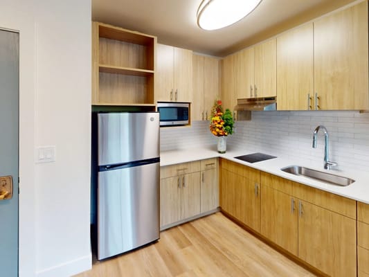 Modern kitchen area with wooden cabinets and appliances