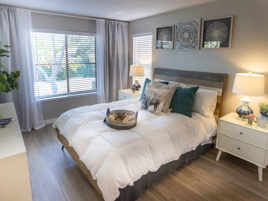 Bright and cozy resident bedroom with a bed and side tables