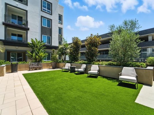 Outdoor lounge area with seating and greenery