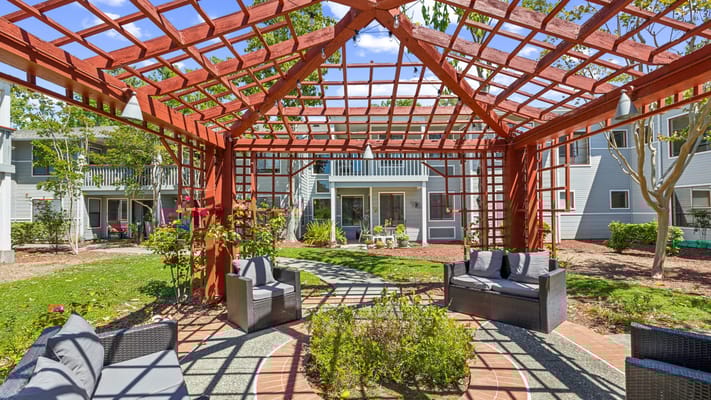 Outdoor seating area with trellis and landscaping