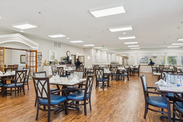Bright dining room with tables set for residents