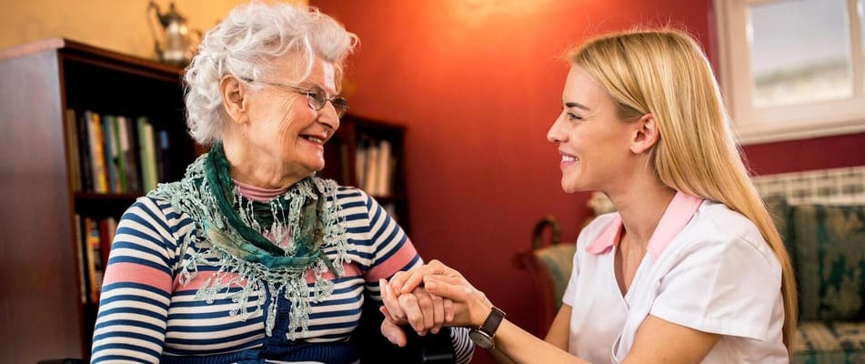A caregiver and resident sharing a warm moment indoors