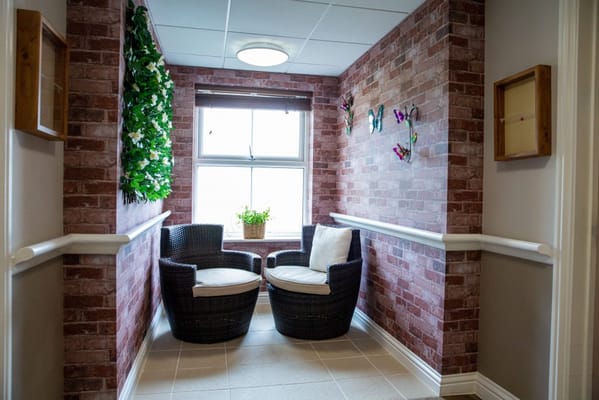 Cozy interior seating area with plants and brick walls