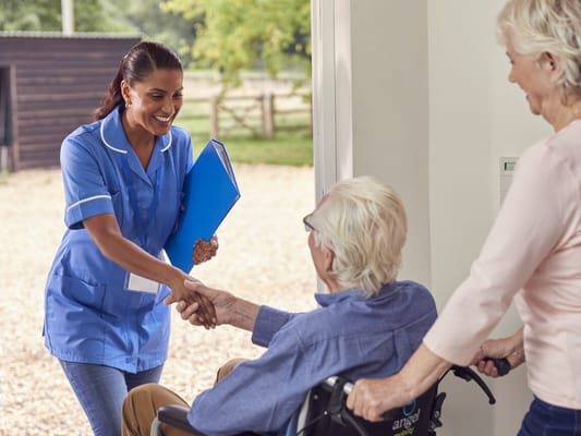 Staff greeting a resident outside the facility